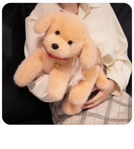 Close-up of soft plush Labrador puppy toy with red collar and bell held by a model