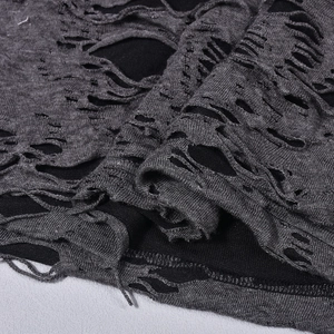 Macro shot of distressed cutout fabric details and layered knit texture on a sexy mini dress