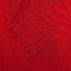 Close-up of red mesh fabric featuring sparkling rhinestone floral patterns on the dress