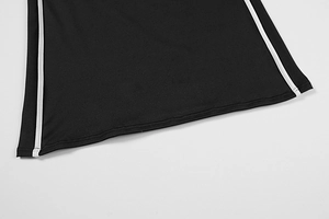 Detail of black mini dress hem featuring white side stripes and premium knit texture