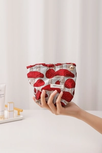 Close-up of vintage mushroom jacquard fabric pouch held in hand for size display
