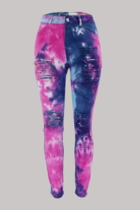 Detailed macro view of pink and blue tie-dye denim fabric with distressed ripped details