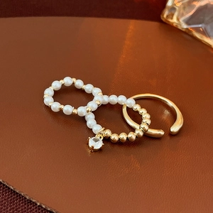 Detailed view of three-piece gold ring set with pearls and zircon on leather