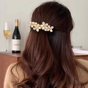 Elegant opal flower hair clip for women in cream white with gold finish on model