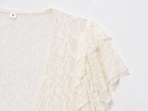Détail du col en dentelle blanche montrant la texture du crochet et l'étiquette taille S