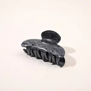 Detailed view of the elegant black and white marble ink texture on an acetic hair claw clip
