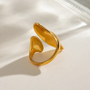 Detailed view of an irregular gold-plated open ring on a textured surface