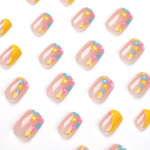 Faux ongles carrés courts avec pointes françaises jaunes et motifs de marguerites colorées