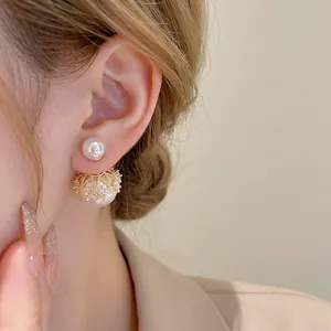 Gold plated crown pearl earrings with crystal inlay shown on a model side profile