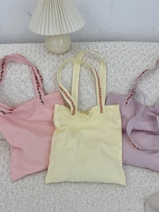 Sacs cabas en toile pastel avec bretelles brodées de fleurs en rose, jaune et violet