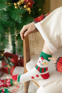Cosy Christmas coral fleece socks with snowman pattern in festive winter setting