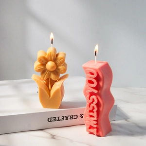 Detail van bloemvormige en 'I MISS YOU' reliëfgeurkaarsen op een marmeren ondergrond