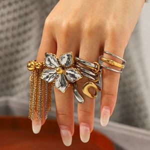 Detail of mixed-metal flower ring and layered tassels on model hand for elegant styling
