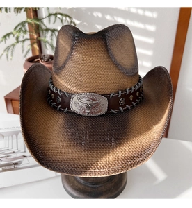 Détail d'un chapeau de cowboy en paille avec bande en cuir et boucle tête de taureau