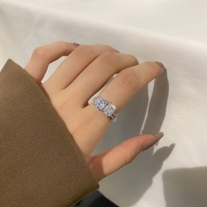 Detail of s925 silver ring featuring dual emerald cut zircons on a pavé diamond band