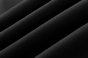 Detailed close-up of high-density black pleated fabric with vertical texture and soft finish