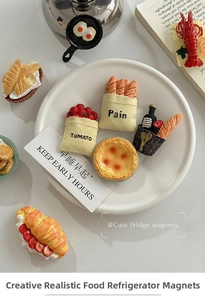 Detailed 3D food magnets featuring egg tart, baguette, and croissant on a white plate