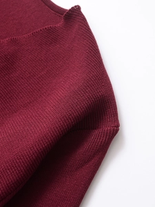 Close-up of fine ribbed texture and precise stitching on a burgundy knitted cardigan