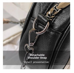 Close-up detail of the detachable chain strap and lychee grain leather on black handbag