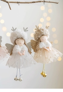 Close-up of mesh angel dolls with plush antlers and bells on a lit Christmas tree