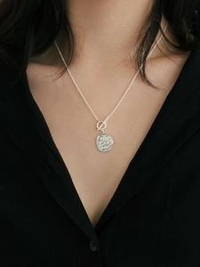 Detailed view of silver 925 coin pendant with OT toggle clasp on a female model