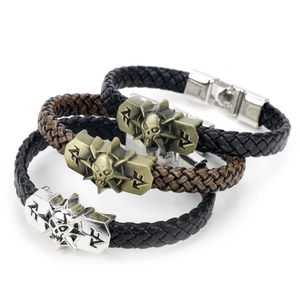 Detail of woven leather bracelets with skull and star charms in bronze and silver