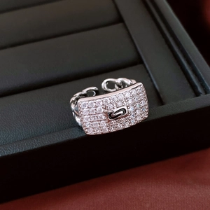 Macro shot of silver ring featuring cubic zirconia pave plate with a black S logo detail