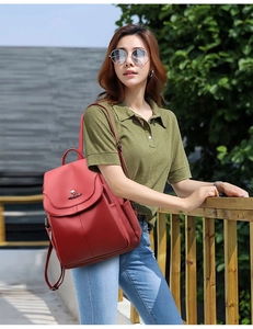 Outdoor model showing the red textured faux leather backpack with a metal kangaroo logo