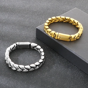 Close-up of gold and silver textured Cuban chain bracelets with wide folding safety clasps