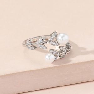 Elegant leaf branch open ring with zircon inlay and double pearls on a pink stand