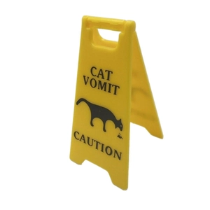 Yellow A-frame plastic caution sign featuring funny black Cat Vomit text and cat silhouette