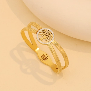Detailed shot of golden stainless steel double-layer bracelet with tree of life charm