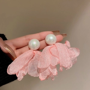 Detail of pink tulle flower earrings featuring iridescent pearl beads and layered fabric petal
