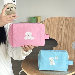 Detail of pink and blue dog print makeup bags with zipper and portable handle strap