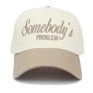 Detail showing 'Somebody's PROBLEM' embroidery on two-tone beige and khaki trucker hat