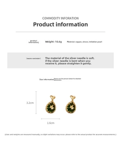 Detail showing green teardrop earring with gold heart, star, and pearl accents