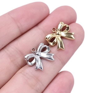 Close-up of small 304 stainless steel bow pendants in gold and silver for DIY jewelry
