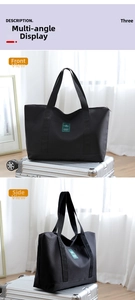 Front and side views of a large black travel canvas tote bag placed on silver luggage