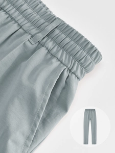 Détail de la taille élastique et des coutures de poche sur ce pantalon bleu-gris
