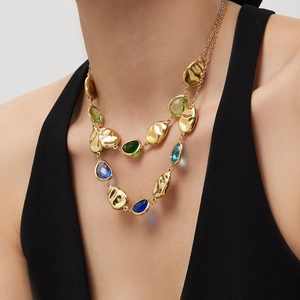 Double-layered gold necklace with colorful faceted gemstones and organic metal shapes
