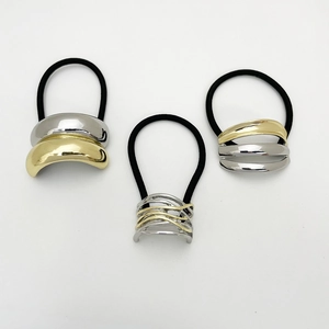 Detailed view of three elastic hair ties with gold and silver geometric metal accents