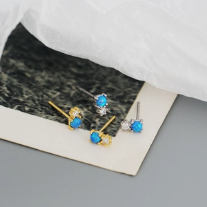 Detail of S925 silver opal stud earrings with cubic zirconia in gold and silver finish