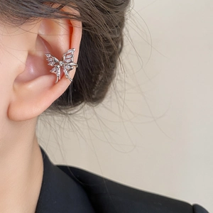 Détail d'un ear cuff papillon argenté avec zircons blancs porté par un mannequin