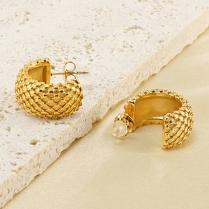 Vue macro de boucles d'oreilles créoles en acier inoxydable 18K à motif de grille gravé