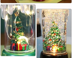 Detail view of two Christmas candle lanterns with LED lights and holiday miniatures