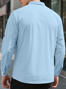 Outdoor back view of men's light blue linen shirt with textured fabric and stand collar