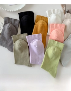 Flat lay of colorful cotton socks in ten pastel shades on a minimalist background