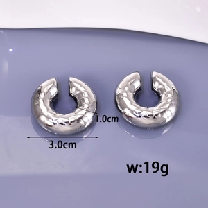 Retro C-shape hollow silver earrings with textured finish on purple background