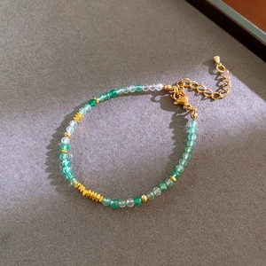 Detail of green crystal beaded bracelet with faceted beads and gold metal spacers