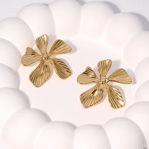 Exaggerated 18K gold plated stainless steel flower earrings on white ceramic tray